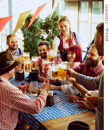 Traditional celebration of beer festival. Group of cheerful people, men and women at bar, drinking beer and having fun 118085653