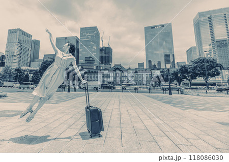 キャリーバッグをひいて旅にでた、若い女性の心弾む様子 キャリーバッグをひいて旅にでた、若い女性の心弾む様子 118086030