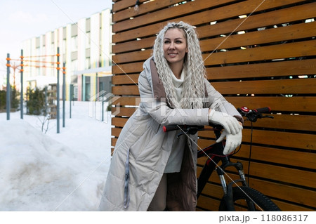Woman Standing Next to Bike in Snow Woman Standing Next to Bike in Snow 118086317