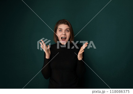 Startled Woman in Front of Green Wall 118086375
