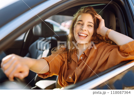 Smiling woman driving a car. Young traveler driving. Car travel, lifestyle concept. Smiling woman driving a car. Young traveler driving. Car travel, lifestyle concept. 118087364