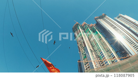 Mumbai, India. Black Kites Fly Above Slums Of Mumbai - Milvus Migrans. Bottom View On Modern Skyscrapers From Dhobi Ghat. Orange Sign Flutters In Wind In Motion. Dhobi Ghat Is Open Air Laundry. Every Mumbai, India. Black Kites Fly Above Slums Of Mumbai - Milvus Migrans. Bottom View On Modern Skyscrapers From Dhobi Ghat. Orange Sign Flutters In Wind In Motion. Dhobi Ghat Is Open Air Laundry. Every 118087905