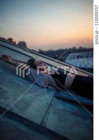 Young woman in roof enjoying sunset, freedom city atmosphere. People, lifestyle, relaxation concept. 118088297