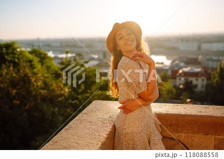 Portrait of happy tourist in hat at dawn enjoys cityscape. Traveling in Europe. Concept tourism. Portrait of happy tourist in hat at dawn enjoys cityscape. Traveling in Europe. Concept tourism. 118088558