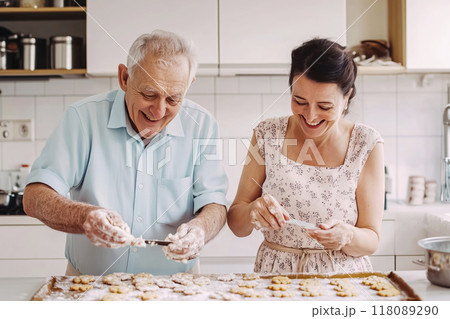 Happy senior couple baking cookies together in the kitchen Happy senior couple baking cookies together in the kitchen 118089290