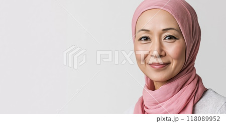 Woman wearing pink headscarf smiling for breast cancer awareness 118089952