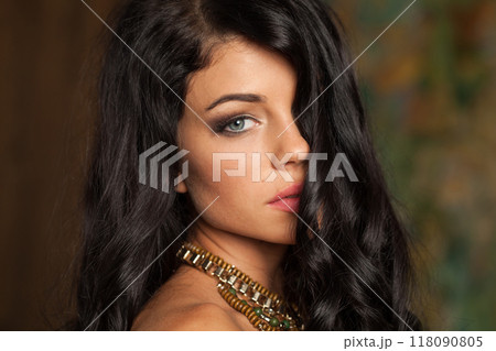 Indoor portrait of young adult woman with long wavy hair and make-up 118090805