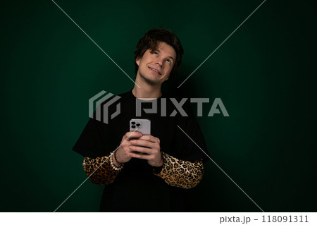 Man Holding Cell Phone Against Green Background 118091311