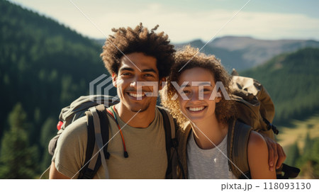 Smiling POC couple hiking with backpacks in mountains on sunny day 118093130