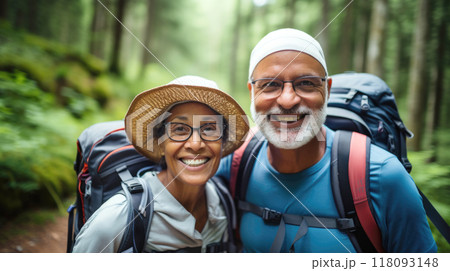Middle aged couple walking on forest path with backpacks in summer Middle aged couple walking on forest path with backpacks in summer 118093148