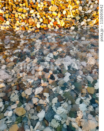 A rocky shoreline with a body of water in the foreground 118093642