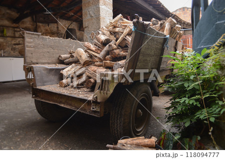 Close up of trailer with firewood in background rural landscape. Concept of help preparing for winter in rural area 118094777