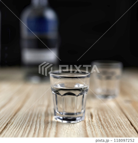 vodka in a glass on a wooden table 118097252
