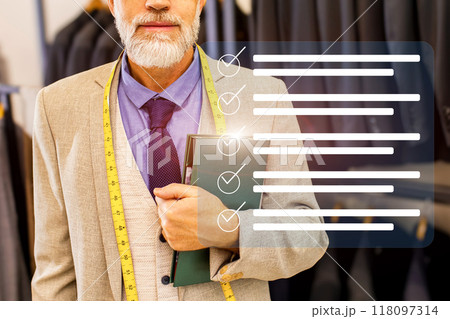 A man is holding a book and a tape measure 118097314