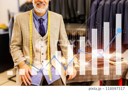 A man in a suit is standing in front of a table with a tape measure 118097317