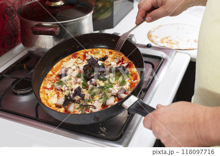 Let's quickly cook pizza in a frying pan at home. Let's quickly cook pizza in a frying pan at home. 118097716
