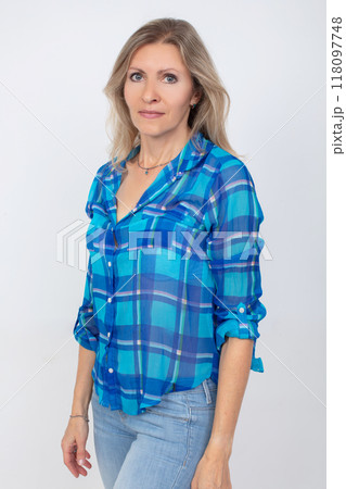 Beautiful middle-aged blonde woman with a slim figure in casual clothes, shirt and jeans Beautiful middle-aged blonde woman with a slim figure in casual clothes, shirt and jeans 118097748