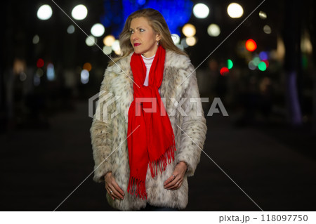 Portrait of a beautiful middle-aged woman in a beautiful evening city. She is looking for a man. 118097750
