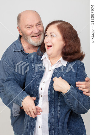 Portrait of an elderly cheerful couple in love in denim clothes. Portrait of an elderly cheerful couple in love in denim clothes. 118097974