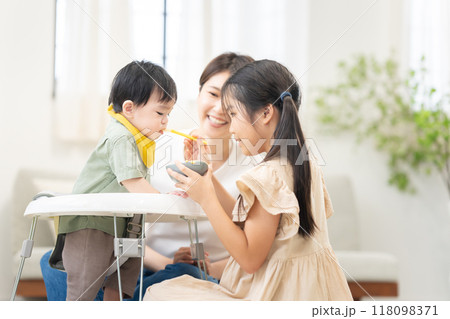 0歳の弟に離乳食を与える姉 118098371