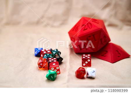 Diverse collection of colored dice on a cardboard surface Diverse collection of colored dice on a cardboard surface 118098399