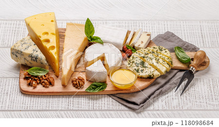 An assortment of various cheeses arranged on a board, highlighting different textures 118098684