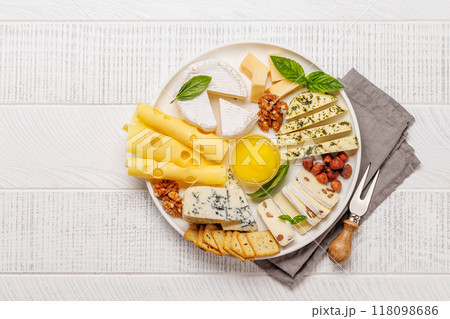 An assortment of various cheeses arranged on a plate, highlighting different textures An assortment of various cheeses arranged on a plate, highlighting different textures 118098686