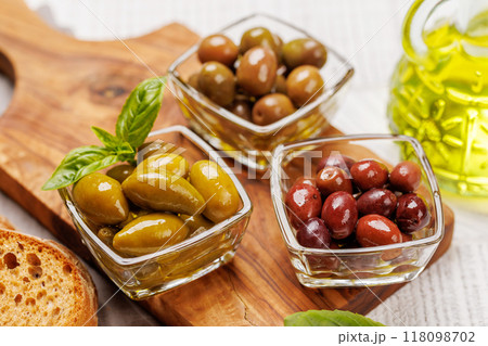 An assortment of various olives presented in a bowl, showcasing different colors, textures, and flavors 118098702