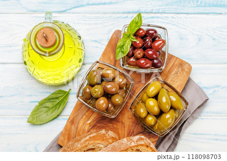 An assortment of various olives presented in a bowl, showcasing different colors, textures, and flavors An assortment of various olives presented in a bowl, showcasing different colors, textures, and flavors 118098703