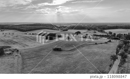 A breathtaking view of a mountain landscape at sunset, with a clear blue sky, soft clouds, and a scenic village below. Perfect for travel, nature, and outdoor-related projects. 118098847