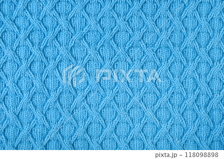 Knitted blue background. Large knitted fabric with a pattern. Close-up of a knitted blanket 118098898