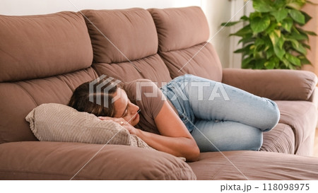 Relaxed woman sleeping on couch in modern apartment Relaxed woman sleeping on couch in modern apartment 118098975