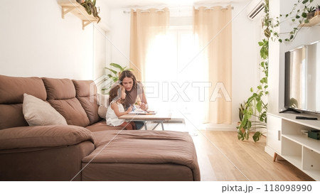 Loving mother and daughter drawing on sofa at home 118098990