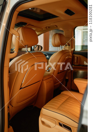 Rear view of driver seat in new vehicle featuring beige leather upholstery and premium interior. Modern looking cabin of demo car at dealership center 118100281