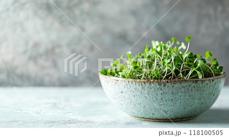 Side view of a ceramic bowl filled with microgreens against a soft light background. Fresh herbs and greens for healthy living. 118100505