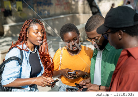 Interested serious group of black students communicate by sharing study information uses smartphones Interested serious group of black students communicate by sharing study information uses smartphones 118103038