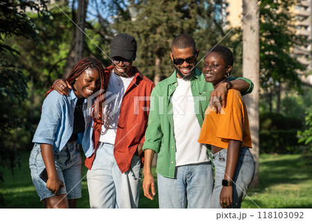 Black students company of friends spending time together, chilling walking in sunny park. Friendship 118103092