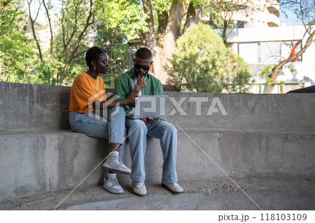 Thoughtful boyfriend, girlfriend classmates using computer to study sitting on campus stairs outside Thoughtful boyfriend, girlfriend classmates using computer to study sitting on campus stairs outside 118103109