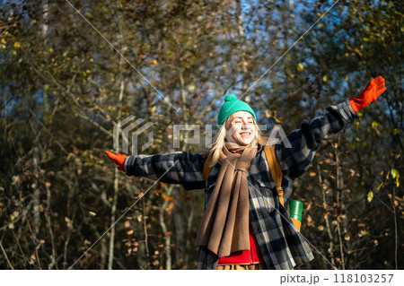 Carefree shiny woman with backpack spinnes with arms outstretched in fall forest. Adventure lover Carefree shiny woman with backpack spinnes with arms outstretched in fall forest. Adventure lover 118103257