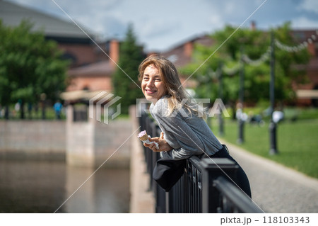 Happy carefree woman with ice cream strolling along waterfront, unwinding in summer. Travel alone 118103343