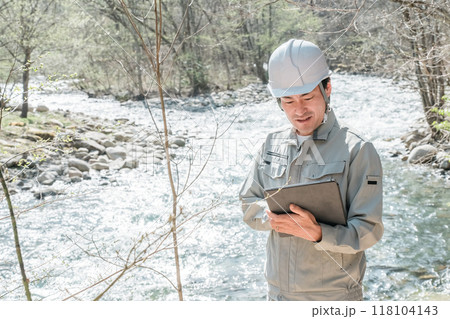 川・河川で河川調査・水質調査をする作業服姿の施工管理技士の男性 118104143