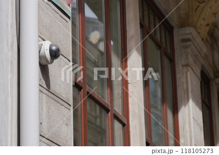 A surveillance camera has been installed on the exterior of the building featuring reflections 118105273