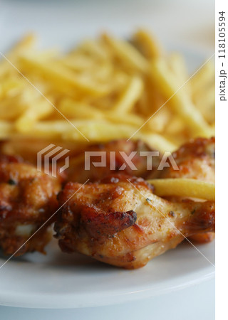 Delicious Chicken Wings with crispy French Fries, beautifully presented on a White Plate Delicious Chicken Wings with crispy French Fries, beautifully presented on a White Plate 118105594