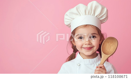 Portrait of a Happy cute little chef smiling girl holding a ladel in the studio with pastel pink bokeh background 118108671