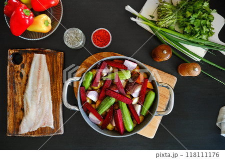 Top view of fresh baby vegetables and raw hake fillet ready for baking 118111176