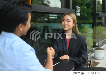 Confident female financial advisor consulting client and reviewing financial data on digital tablet 118111436