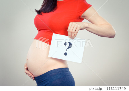 Woman in pregnant holding card with question mark 118111749