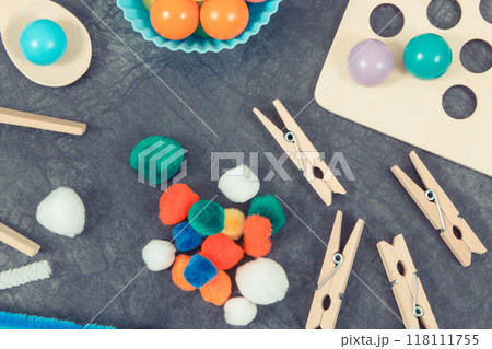 Colorful pompoms, balls and rubber erasers using for development of kids motor skills Colorful pompoms, balls and rubber erasers using for development of kids motor skills 118111755