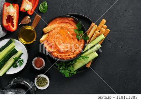 Htipiti - Greek red pepper and feta dip on black bowl on dark background. top view, copy space 118111885