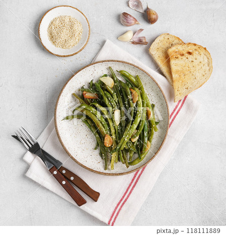 Fried wok green beans with garlic and sesame in a plate on a gray background. Flat lay. Top view. vegetarian dish 118111889